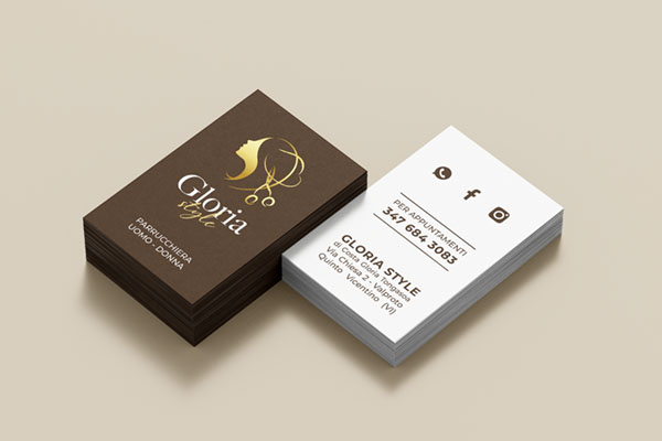 biglietto da visita parrucchiera appoggiato sopra ad un tavolo di colore beige