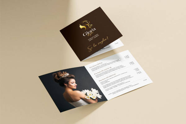 depliant quadrato a due ante per una parrucchiera appoggiato sopra ad un tavolo di colore beige