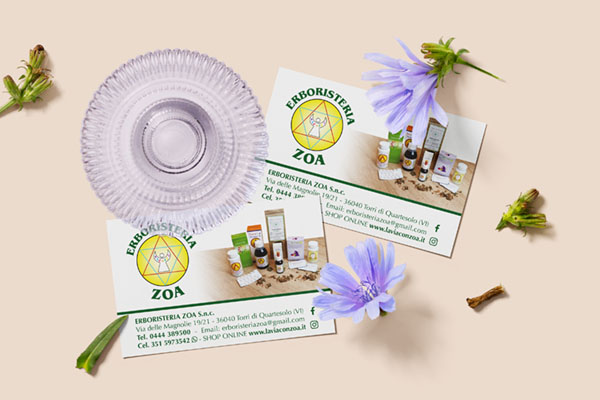 biglietto da visita per erboristeria appoggiato su tavolo con fondo beige ed elementi decorativi di foglie e fiori