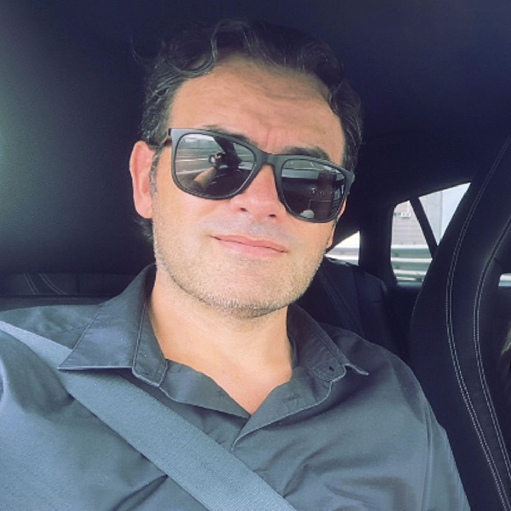 primo piano di uomo con occhiali da sole seduto in macchina